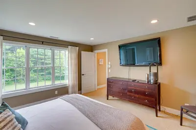 a bedroom with a bed and a flat screen tv at Stockbridge Retreat with Pool and Hot Tub! in Stockbridge