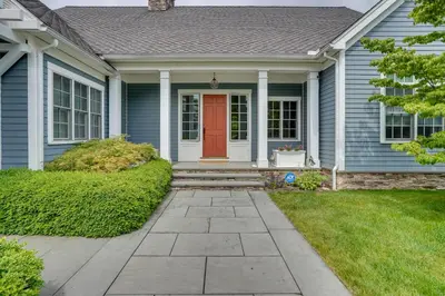 a blue house with a red door at Stockbridge Retreat with Pool and Hot Tub! in Stockbridge