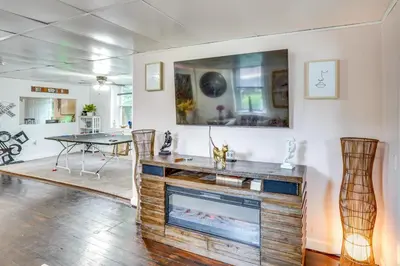 a living room with a fireplace and a table at Cozy Berkshires Vacation Rental Near Hiking! in Chester
