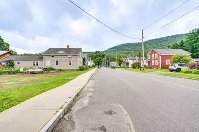 an empty street in a small town with houses at Cozy Berkshires Vacation Rental Near Hiking! in Chester