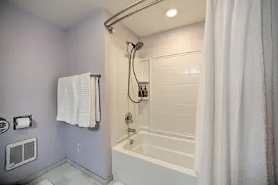 a white bathroom with a tub and a shower at Catskills Farmhouse and Spa in Harpersfield