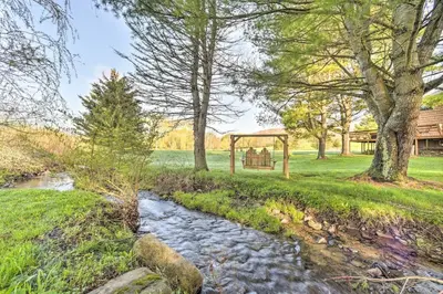 a garden with a creek and a gazebo at Catskills Farmhouse and Spa in Harpersfield