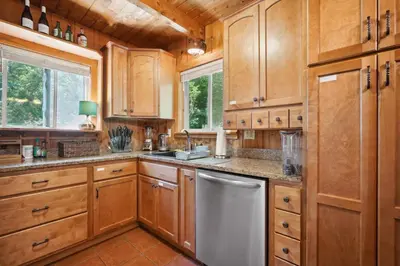 a kitchen with wooden cabinets and a dishwasher at Wilmington Vacation Rental Near Hiking and Skiing! in Wilmington