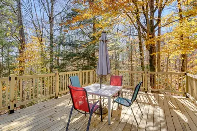 a table with chairs and an umbrella on a deck at Wilmington Vacation Rental Near Hiking and Skiing! in Wilmington