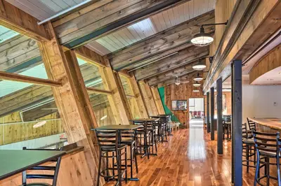 a row of tables and chairs in a room with wooden walls at Wilmington Vacation Rental Near Hiking and Skiing! in Wilmington