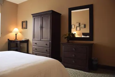 a bedroom with a dresser and a large mirror at Belvedere Inn Schenectady - Albany in Schenectady