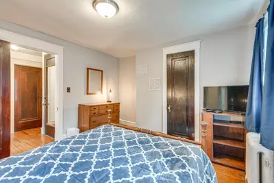 a bedroom with a blue bed and a television at 8 Mi to Elk Mountain Ski Resort Clifford Home! in Clifford
