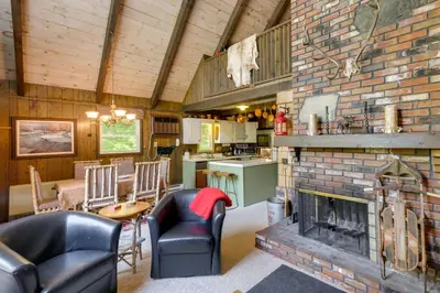 a living room with a brick fireplace and a kitchen at West Dover Home - Steps to Mount Snow Resort! in West Dover