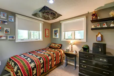 a bedroom with a bed and a dresser and windows at West Dover Home - Steps to Mount Snow Resort! in West Dover
