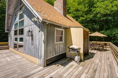 a house with a stroller on a wooden deck at West Dover Home - Steps to Mount Snow Resort! in West Dover