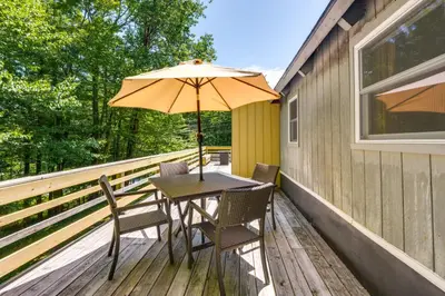 a table and chairs on a deck with an umbrella at West Dover Home - Steps to Mount Snow Resort! in West Dover