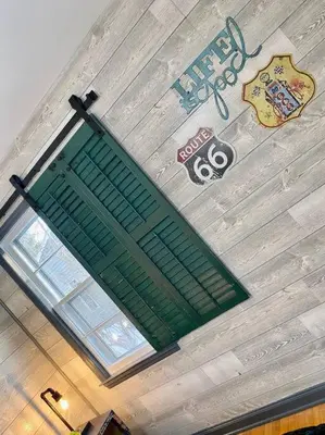 a green shutter on the wall of a building at Rustic Elegance 3BDR Stylish Farmhouse Getaway in Schenectady