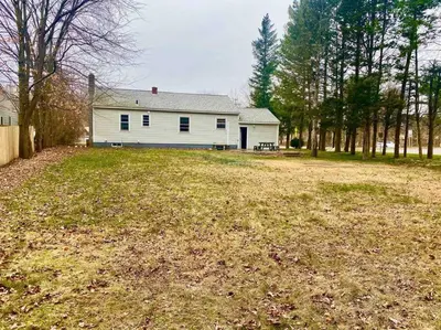a white house in the middle of a yard at Rustic Elegance 3BDR Stylish Farmhouse Getaway in Schenectady