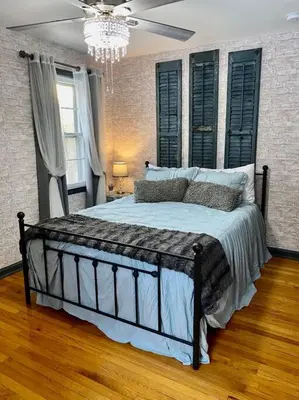 a bedroom with a large bed with black shutters at Rustic Elegance 3BDR Stylish Farmhouse Getaway in Schenectady