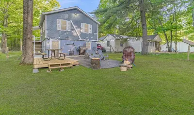 a backyard with a house and a table and benches at Wally's House in Hawley