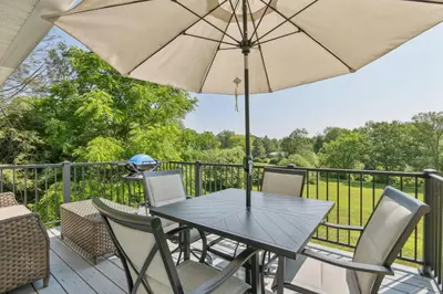 a table and chairs on a deck with an umbrella at Connecticut Retreat Steps to Historic Downtown! in Litchfield