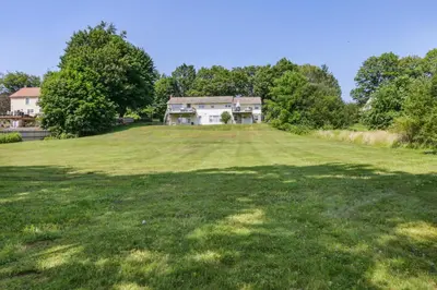 a large field with a house on top of it at Connecticut Retreat Steps to Historic Downtown! in Litchfield