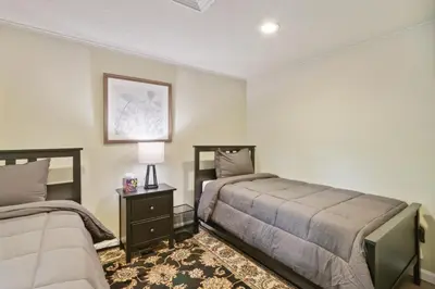 a bedroom with two beds and a table with a lamp at Connecticut Retreat Steps to Historic Downtown! in Litchfield