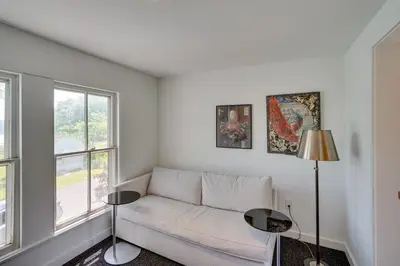 a living room with a white couch and a window at Historic Home in Coxsackie with Hudson River Views! in Coxsackie