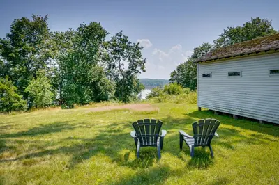 two chairs sitting in the grass next to a building at Historic Home in Coxsackie with Hudson River Views! in Coxsackie