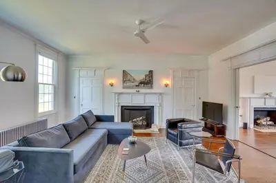 a living room with a blue couch and a fireplace at Historic Home in Coxsackie with Hudson River Views! in Coxsackie