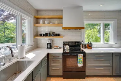 a kitchen with gray cabinets and a stove top oven at Historic Home in Coxsackie with Hudson River Views! in Coxsackie