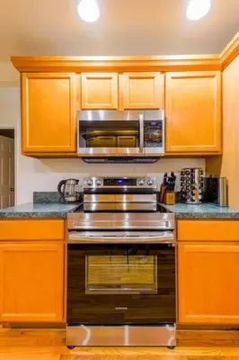 a kitchen with a stainless steel stove and a microwave at Saratoga Serenity: Charming Rental Nearby Downtown in Saratoga Springs