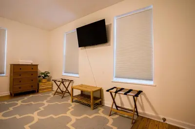 a living room with two chairs and a flat screen tv at Saratoga Serenity: Charming Rental Nearby Downtown in Saratoga Springs