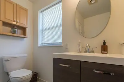 a bathroom with a sink and a toilet and a mirror at Saratoga Serenity: Charming Rental Nearby Downtown in Saratoga Springs