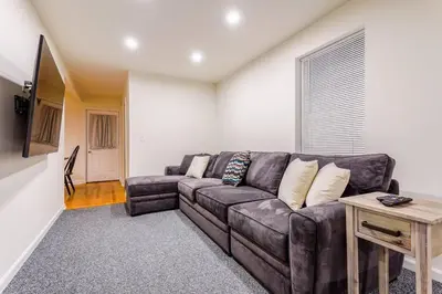 a living room with a brown couch and a table at Saratoga Serenity: Charming Rental Nearby Downtown in Saratoga Springs