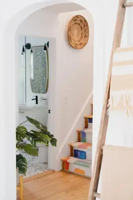 a hallway with a staircase with books and a clock at The Norsdale plus CMYK Motel on 10 acres in Phoenicia in Phoenicia