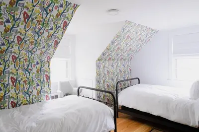 two beds in a room with a curtain and a window at The Norsdale plus CMYK Motel on 10 acres in Phoenicia in Phoenicia