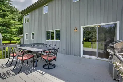 a patio with a table and chairs on a deck at Warwick Vacation Rental with Private Yard and Fire Pit in Warwick