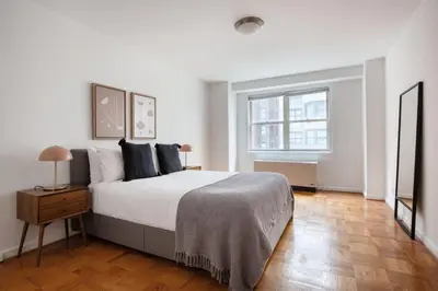 a white bedroom with a bed and a window at UES 1br w elevator doorman nr Central Park NYC-1186 in New York
