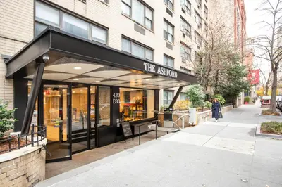 a woman walking in front of a store at UES 1br w elevator doorman nr Central Park NYC-1186 in New York