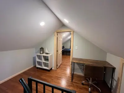 an attic room with a staircase with a desk at Wally's Cabin in Hawley