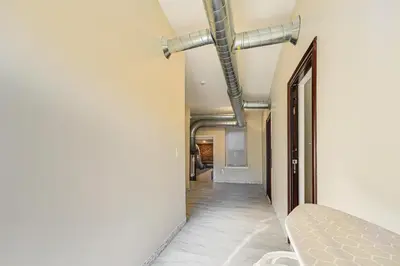 a hallway in a house with pipes on the wall at Walk to Dtwn and Waterfront Roomy Troy Apt in Troy