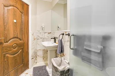 a bathroom with a sink and a wooden door at Walk to Dtwn and Waterfront Roomy Troy Apt in Troy