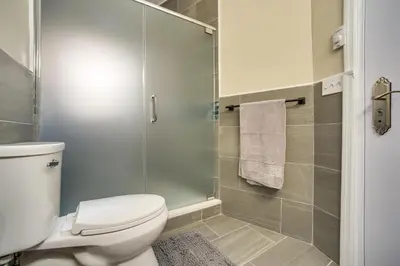 a bathroom with a toilet and a glass shower at Walk to Dtwn and Waterfront Roomy Troy Apt in Troy