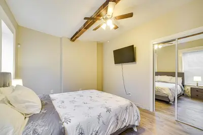 a bedroom with a bed and a flat screen tv at Walk to Dtwn and Waterfront Roomy Troy Apt in Troy