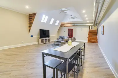 a living room with a table and chairs and a tv at Walk to Dtwn and Waterfront Roomy Troy Apt in Troy