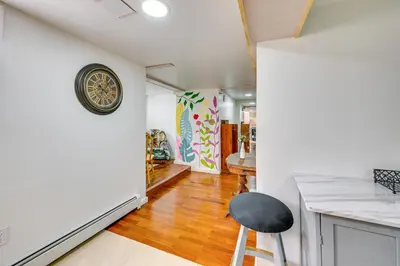 a kitchen with a black stool and a clock on the wall at East Hartford Studio about 4 Mi to Downtown Hartford! in East Hartford