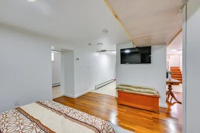 a living room with a couch and a tv on a wall at East Hartford Studio about 4 Mi to Downtown Hartford! in East Hartford