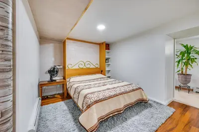 a bedroom with a bed with a wooden headboard at East Hartford Studio about 4 Mi to Downtown Hartford! in East Hartford