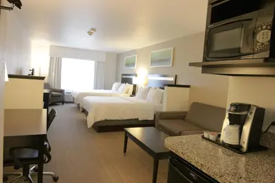 a hotel room with two beds and a couch at Holiday Inn Express and Suites Montgomery by IHG in Montgomery