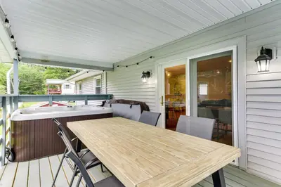 a porch with a wooden table and chairs at Sauna, Fire Pit Spacious and Serene Poconos Getaway in Canadensis