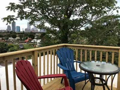 two chairs and a table on a deck with a tree at Cozy Alcove Studio Apt w Outdoor deck w NYC Views in Jersey City