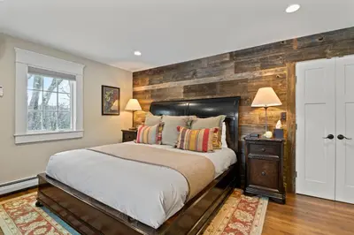 a bedroom with a bed and a wooden wall at Brook Bound Inn in Wilmington