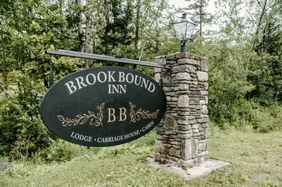 a sign for a brick wound inn with a street light at Brook Bound Inn in Wilmington