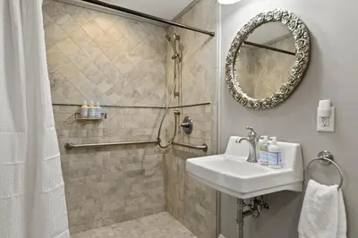 a bathroom with a sink and a shower with a mirror at Brook Bound Inn in Wilmington